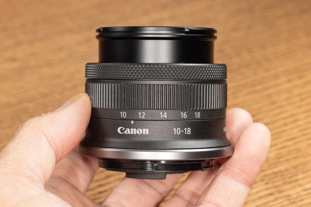 Компактний надширококутний зум Canon RF-S 10-18mm f/4.5-6.3 IS STM у долоні оператора